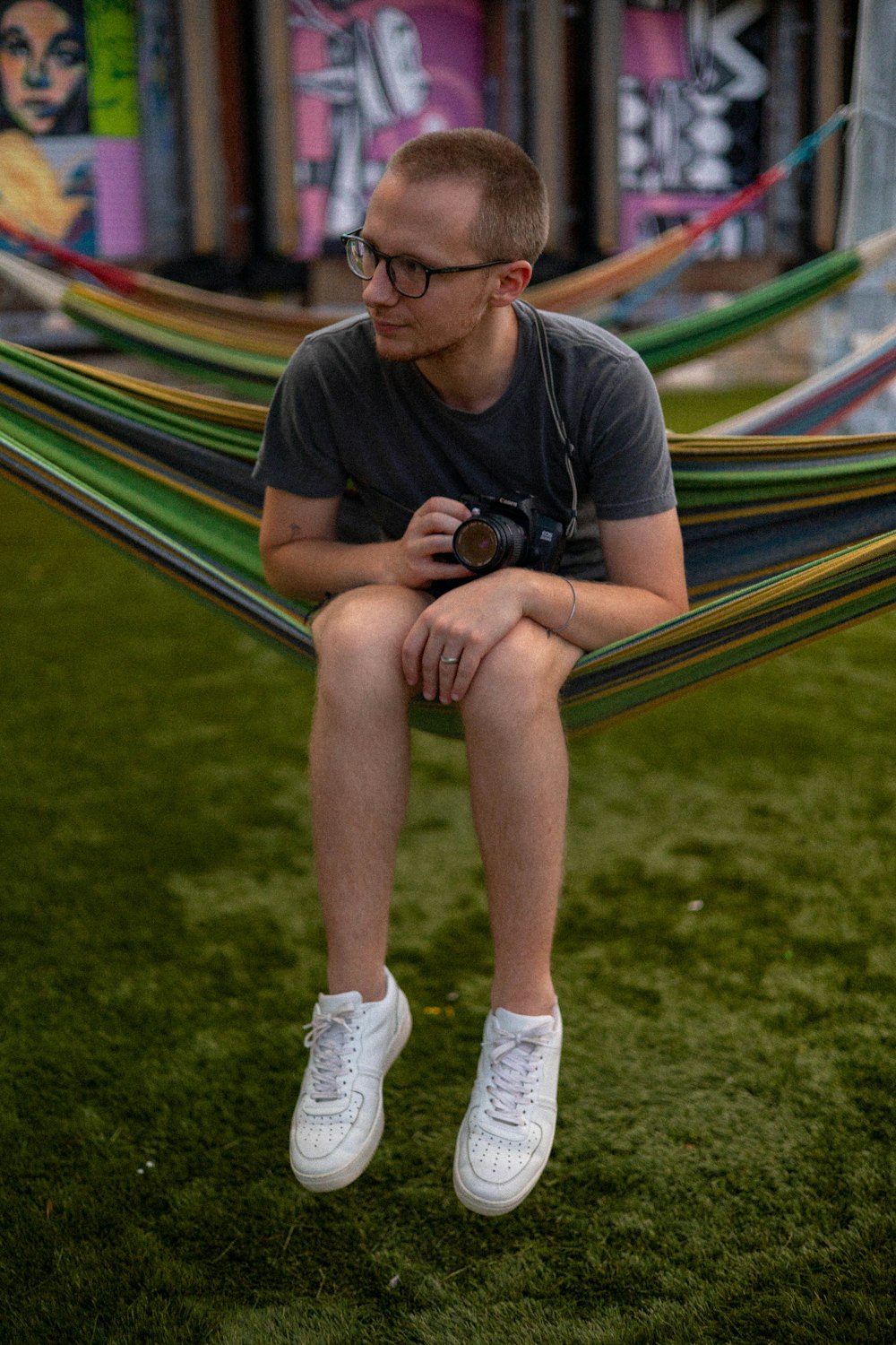a man sitting in a hammock with a camera