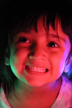 Close-up of a young child smiling while wearing 3D glasses inside the 7D cinema.