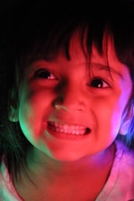 A cheerful child smiling brightly in a colorful dental office with playful decorations.