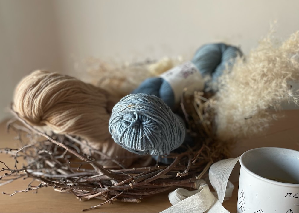 a bird nest with yarn and a cup of coffee