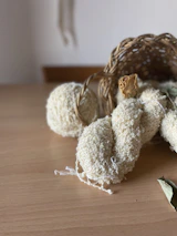 A simple resin table ornament beside a woven fruit storage container on a wooden table.