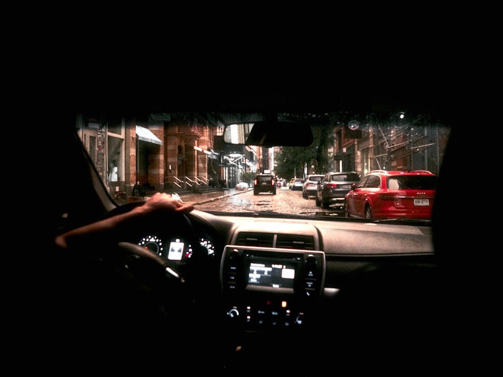 una persona que conduce un automóvil por una calle por la noche