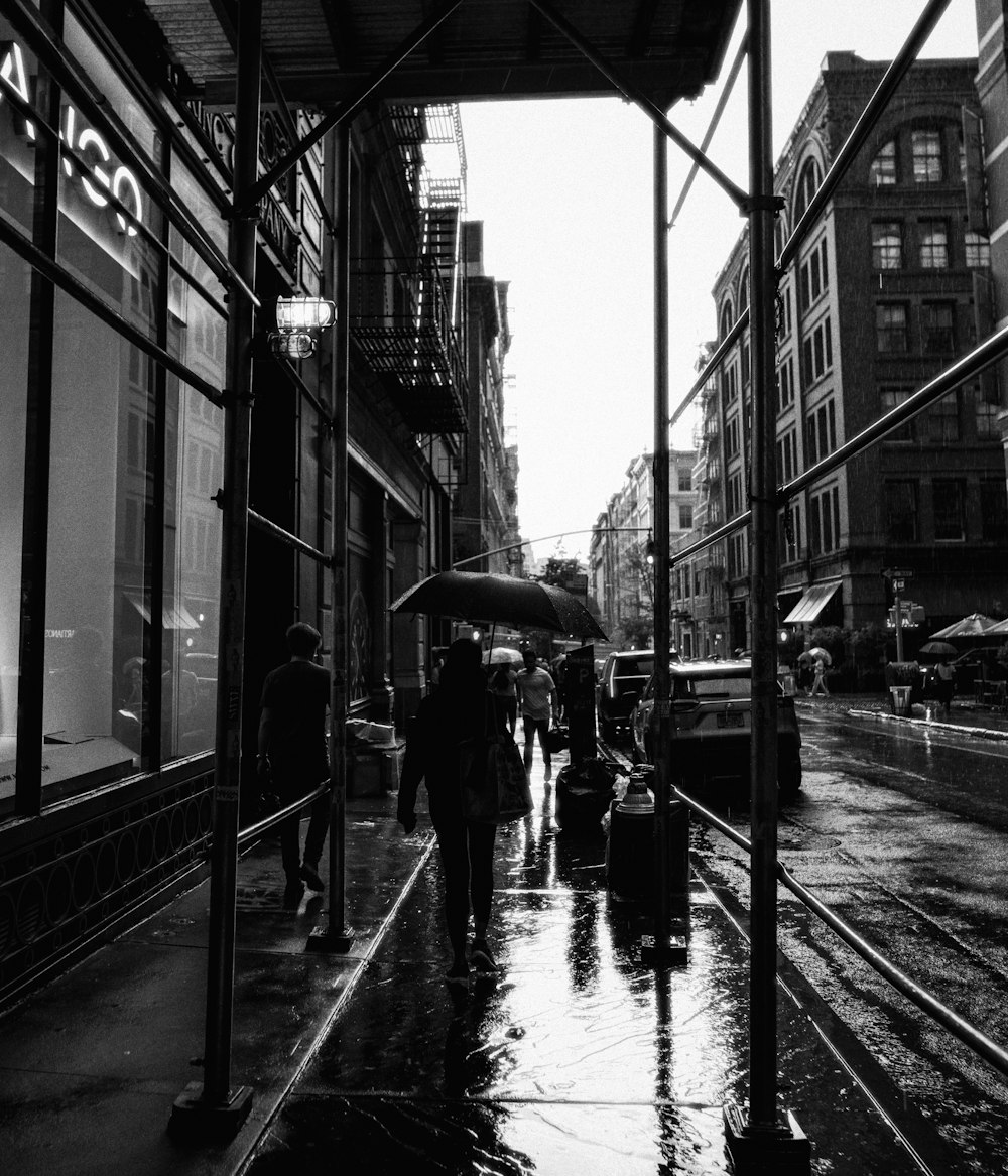 a group of people walking down a rain soaked street