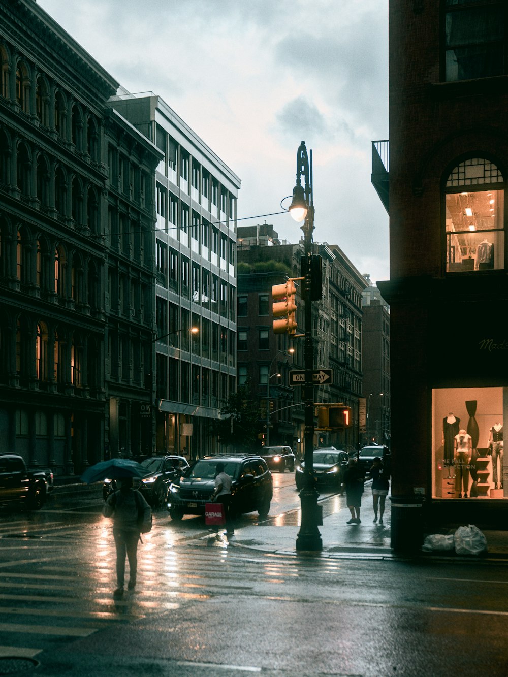 a group of people walking down a rain soaked street