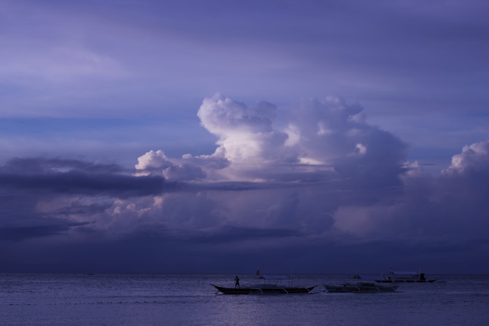 a couple of boats floating on top of a large body of water