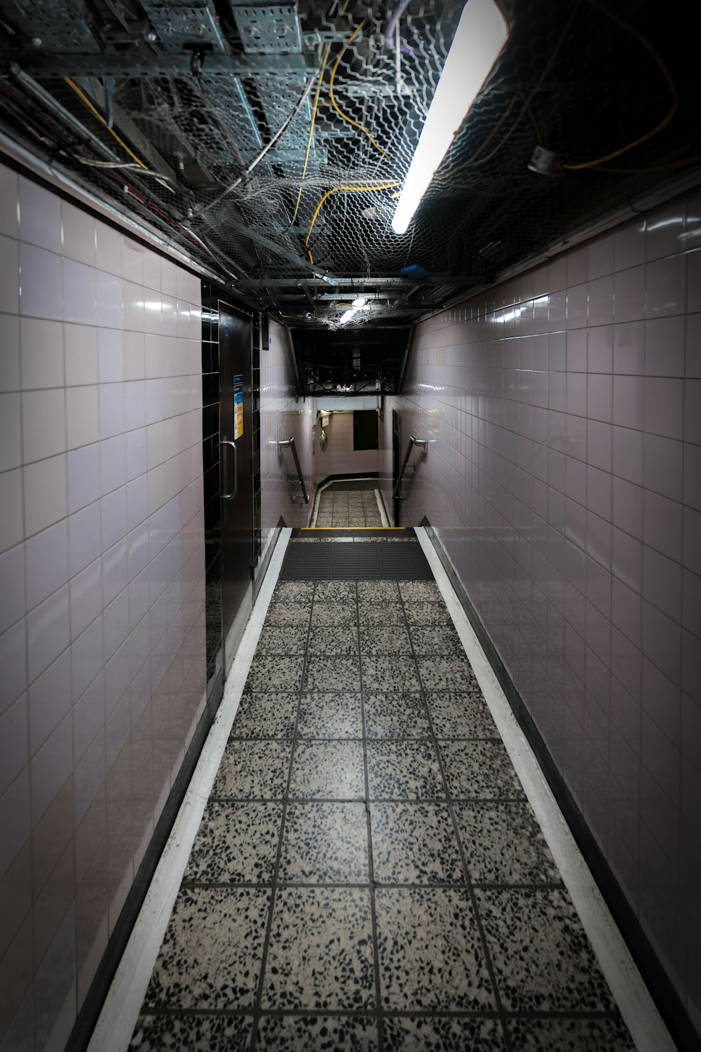 a long hallway with a tiled floor and walls