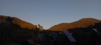 A fleet of mobile telecom units parked in a valley surrounded by steep hills.