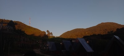 A fleet of mobile telecom units parked in a valley surrounded by steep hills.