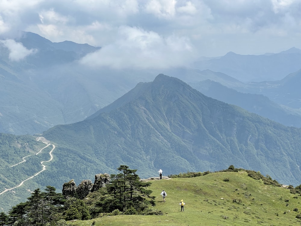 a couple of people that are standing on a hill