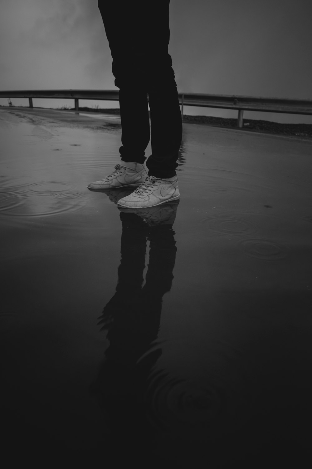 a person standing in the rain with their feet in the water