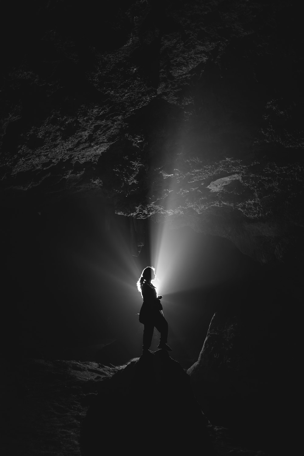a person standing on top of a rock under a light