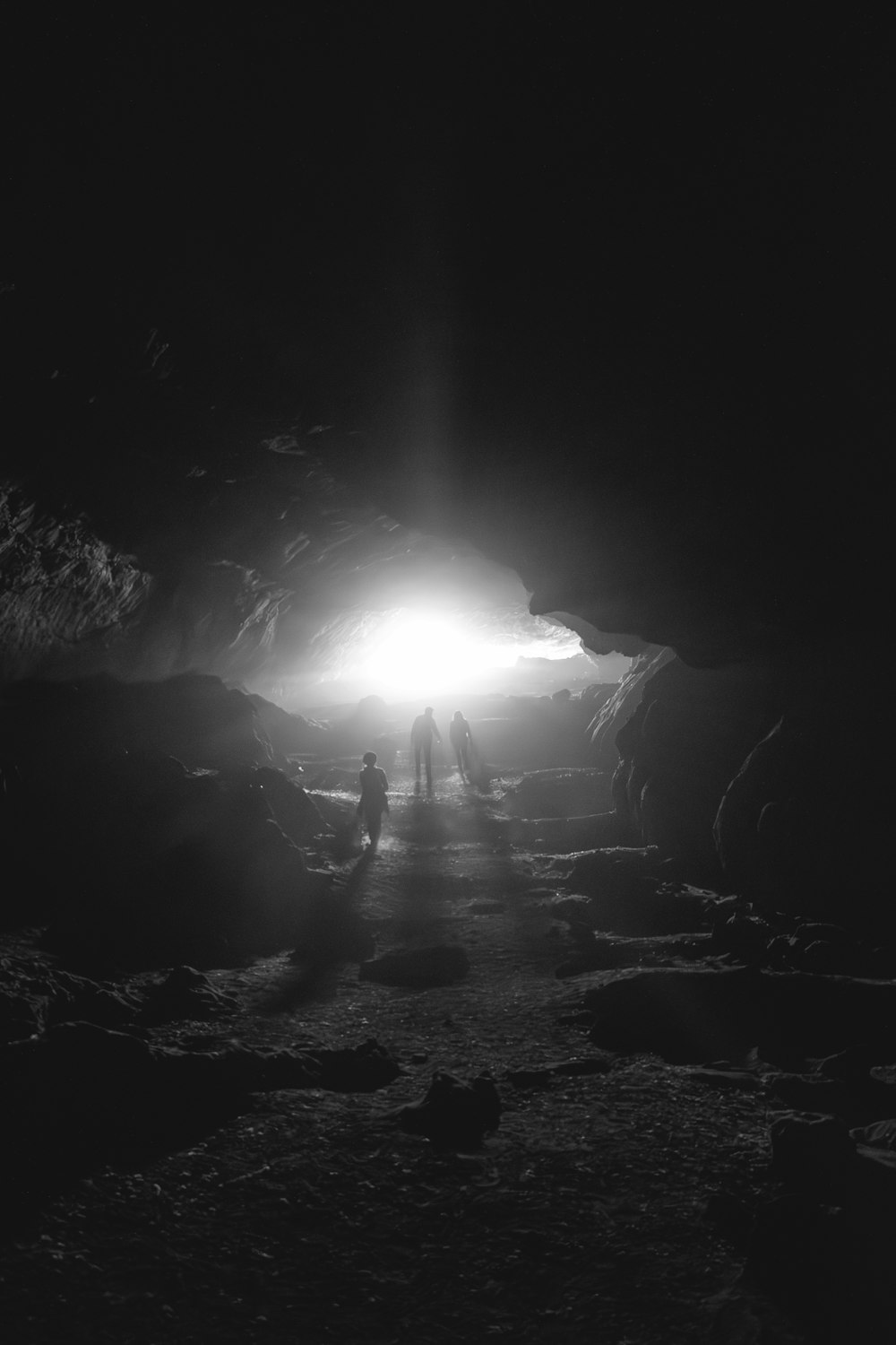 a couple of people standing in a cave