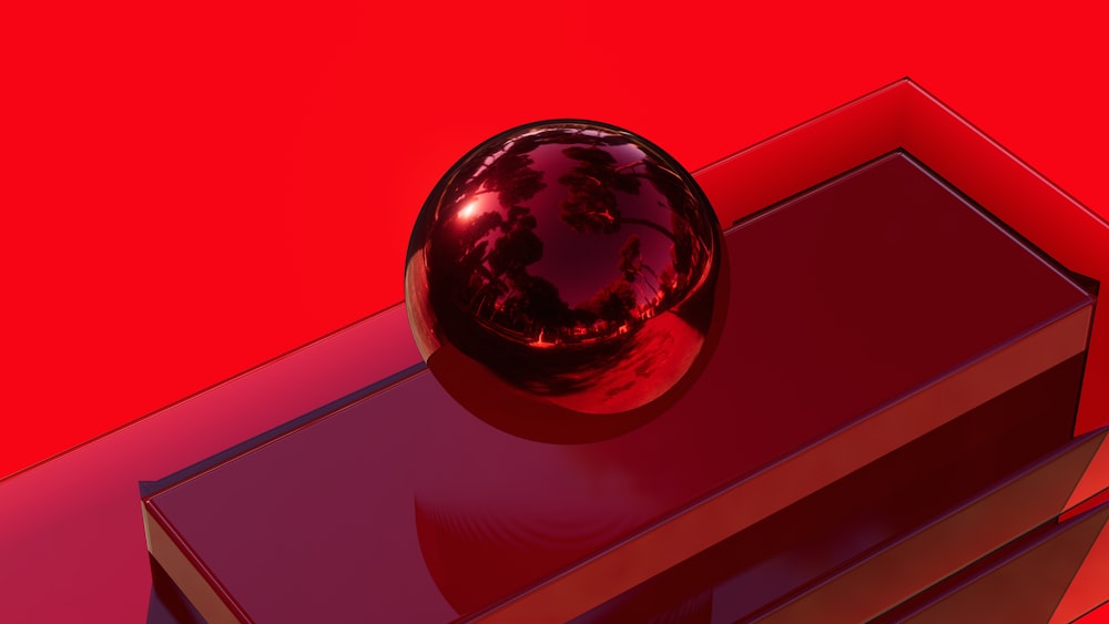 a shiny red object sitting on top of a book