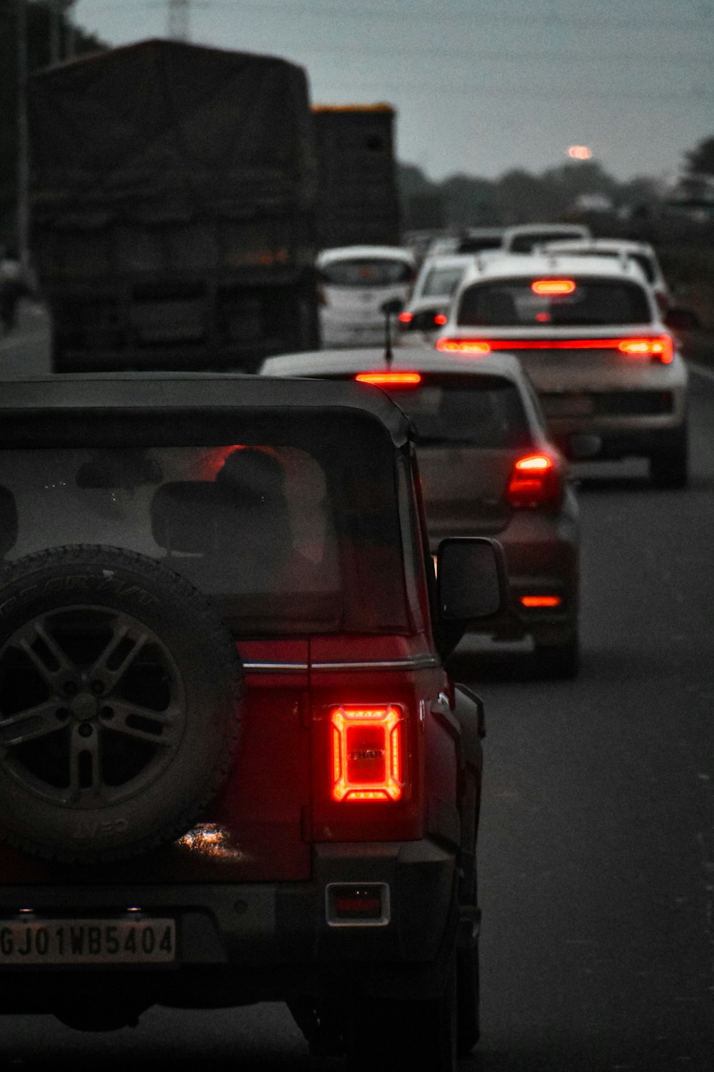 a group of cars driving down a street at night