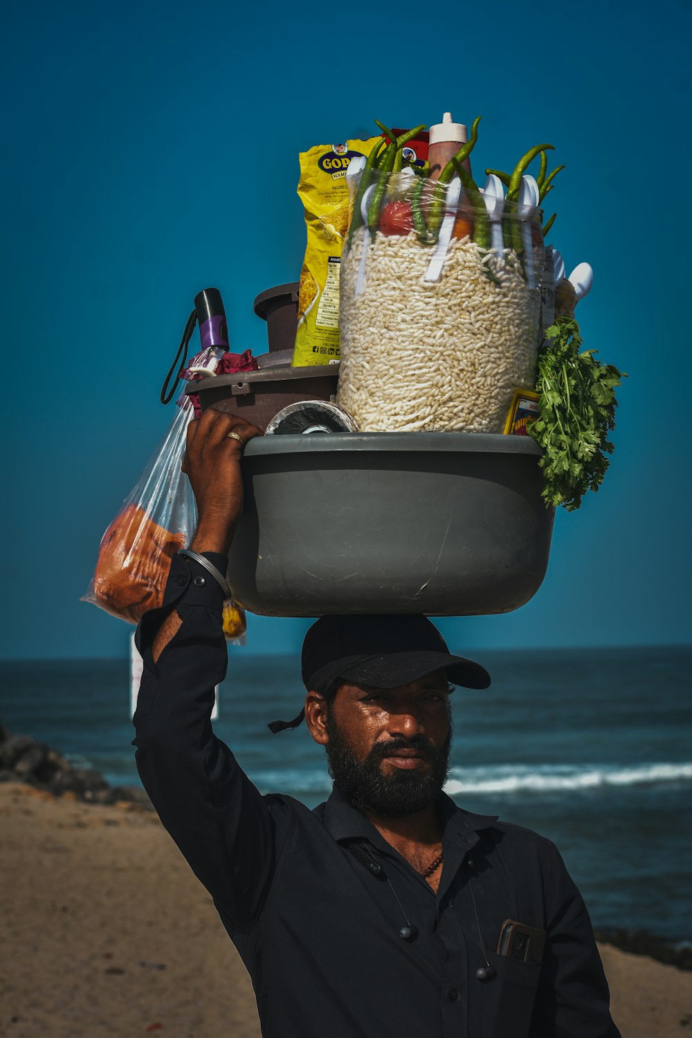 a man carrying a large bowl of food on his head