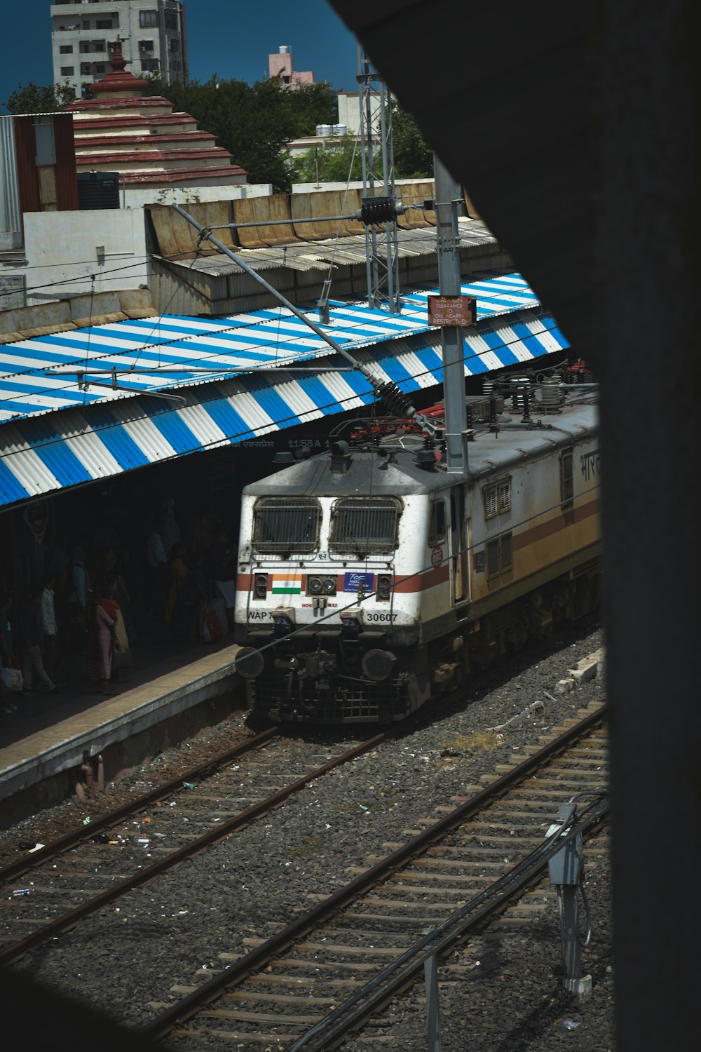 um trem viajando pelos trilhos de trem ao lado de uma estação de trem