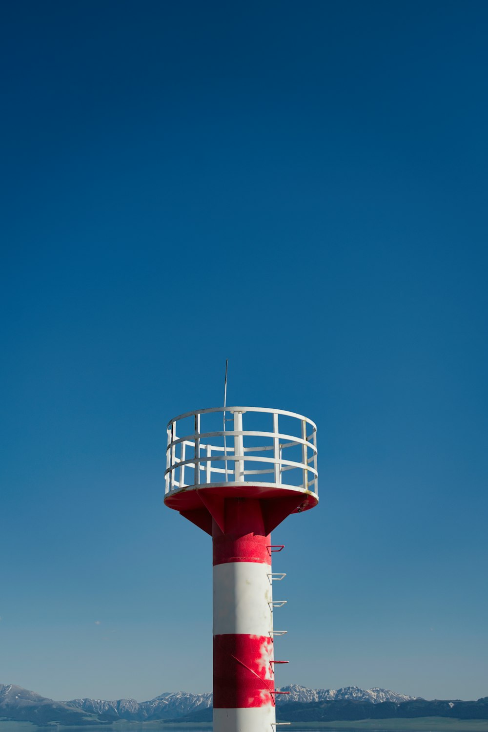 a red and white lighthouse on a clear day