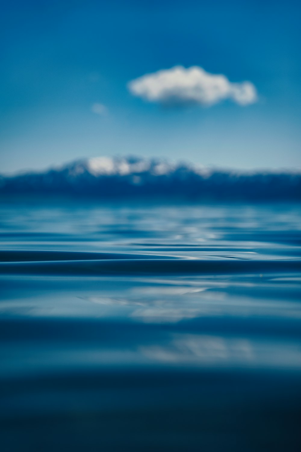 a blue ocean with a cloud in the sky