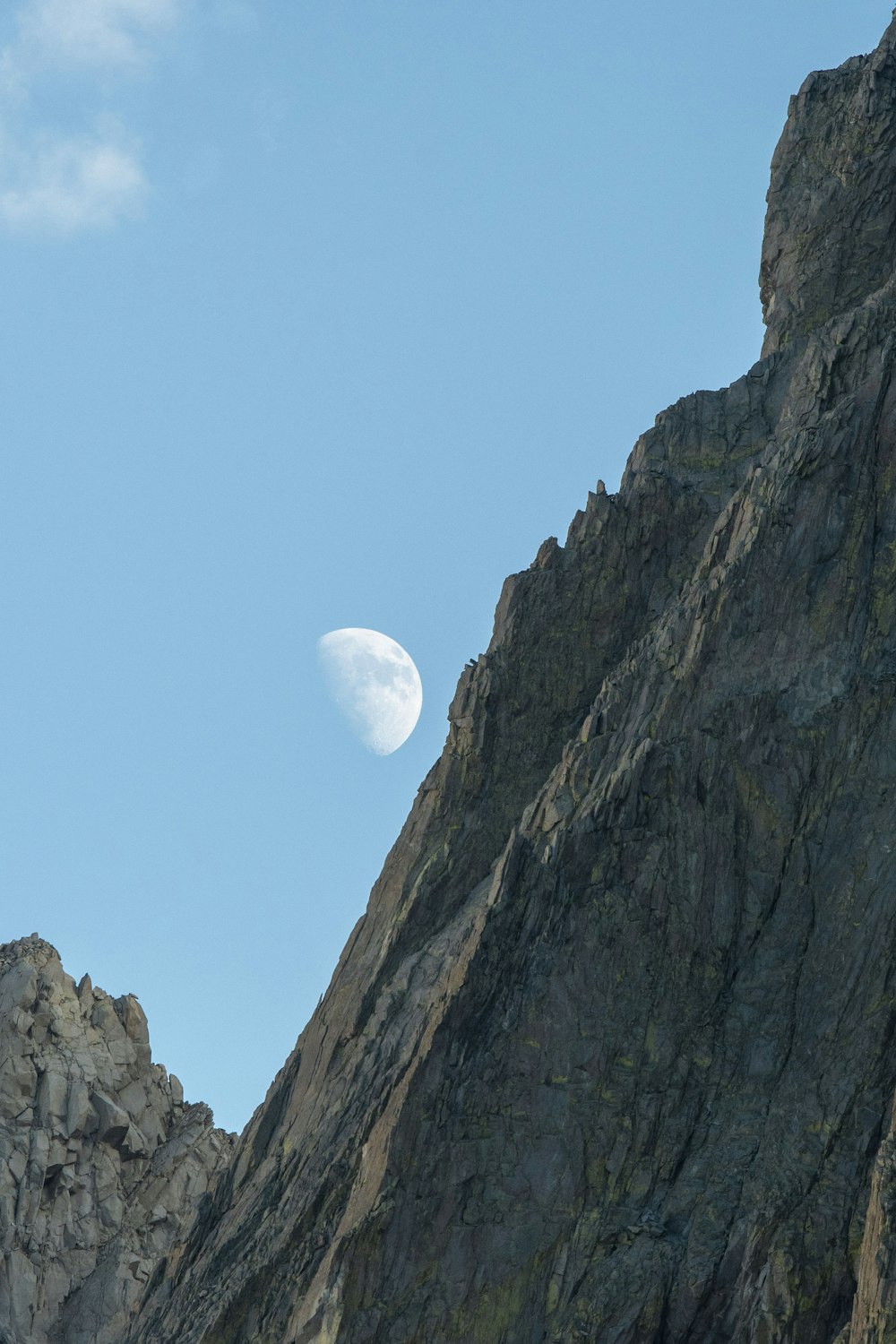 a mountain with a half moon in the sky