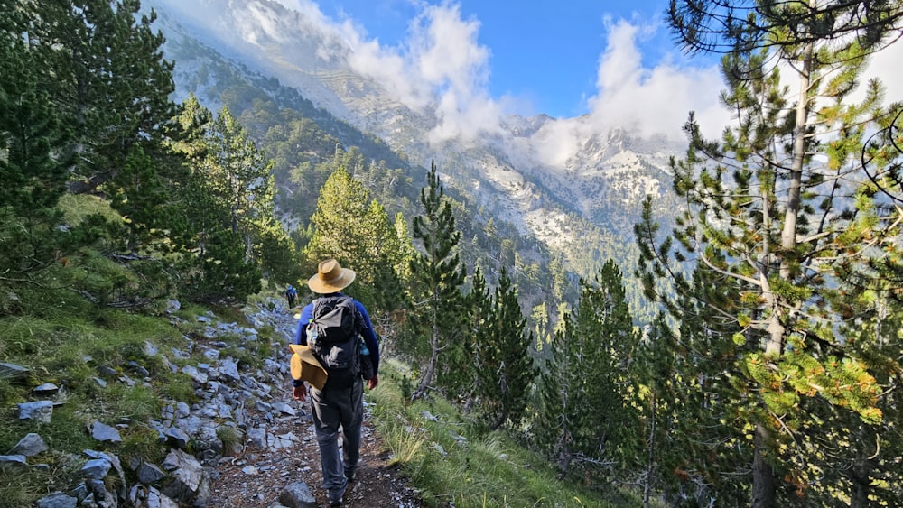 a man hiking up a trail in the mountains