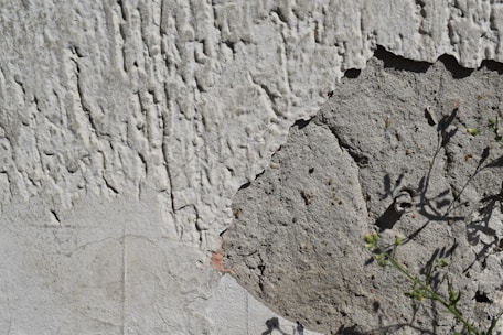 Close-up of a freshly applied stucco wall with smooth, even texture on a sunny day.