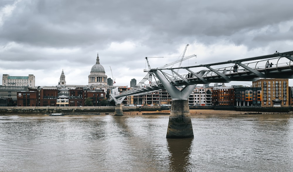 a bridge over a body of water with buildings in the background