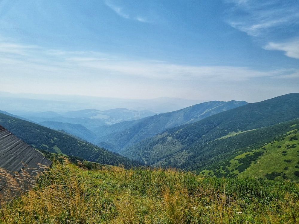 a scenic view of a valley with mountains in the background