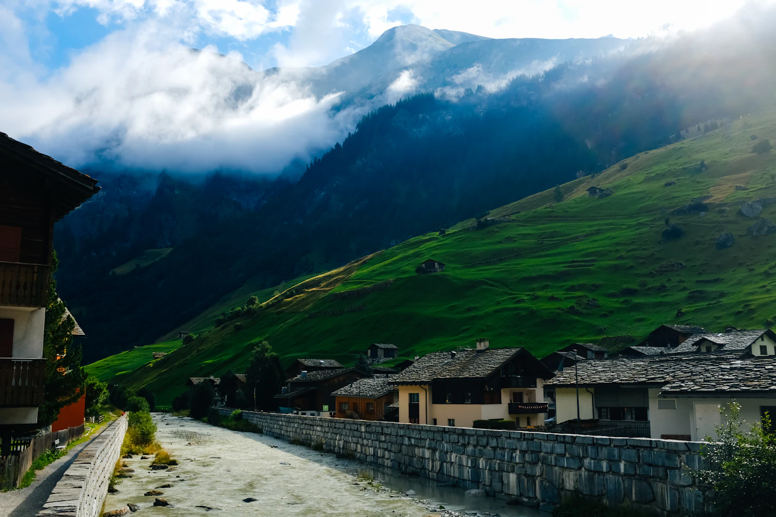 Hameau de montagne blotti au fond d'une vallée alpine (photo d'illustration)