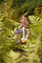 a statue of a gnome holding a basket of grapes