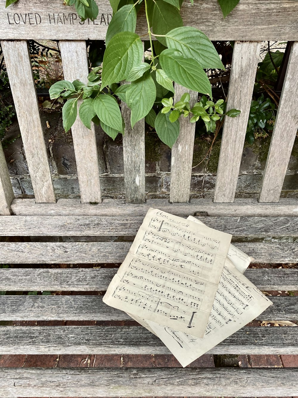 a sheet of music sitting on top of a wooden bench