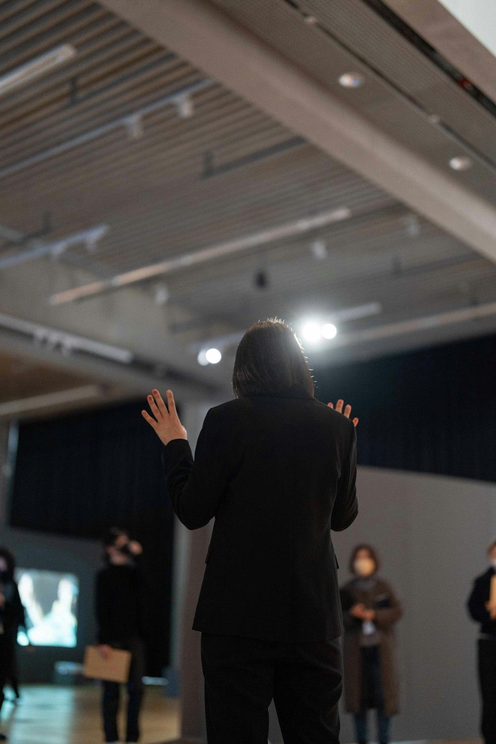 a woman in a suit standing in front of a crowd