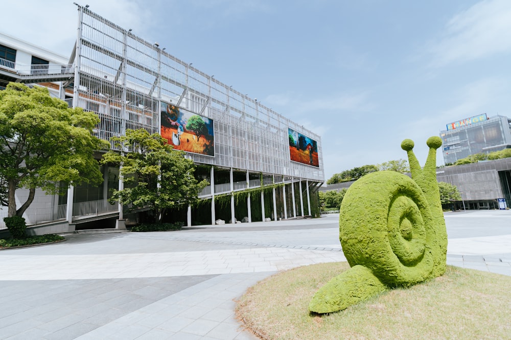 a sculpture of a snail in front of a building