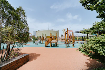 Children happily playing on a wooden climbing frame surrounded by greenery.