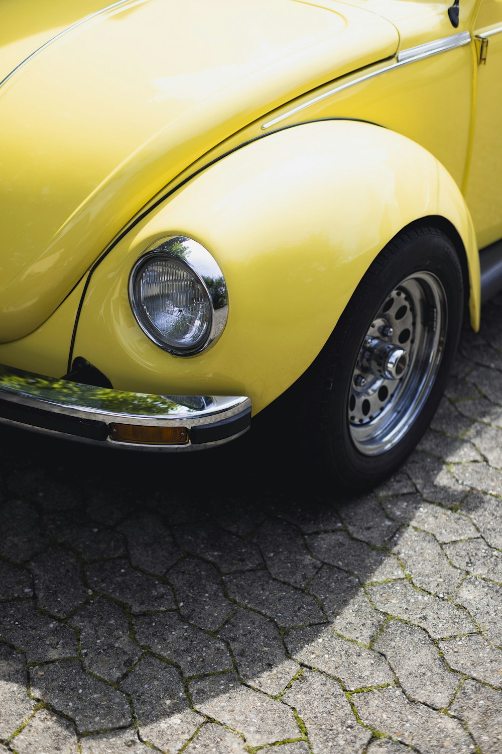 a close up of the front of a yellow vw bug