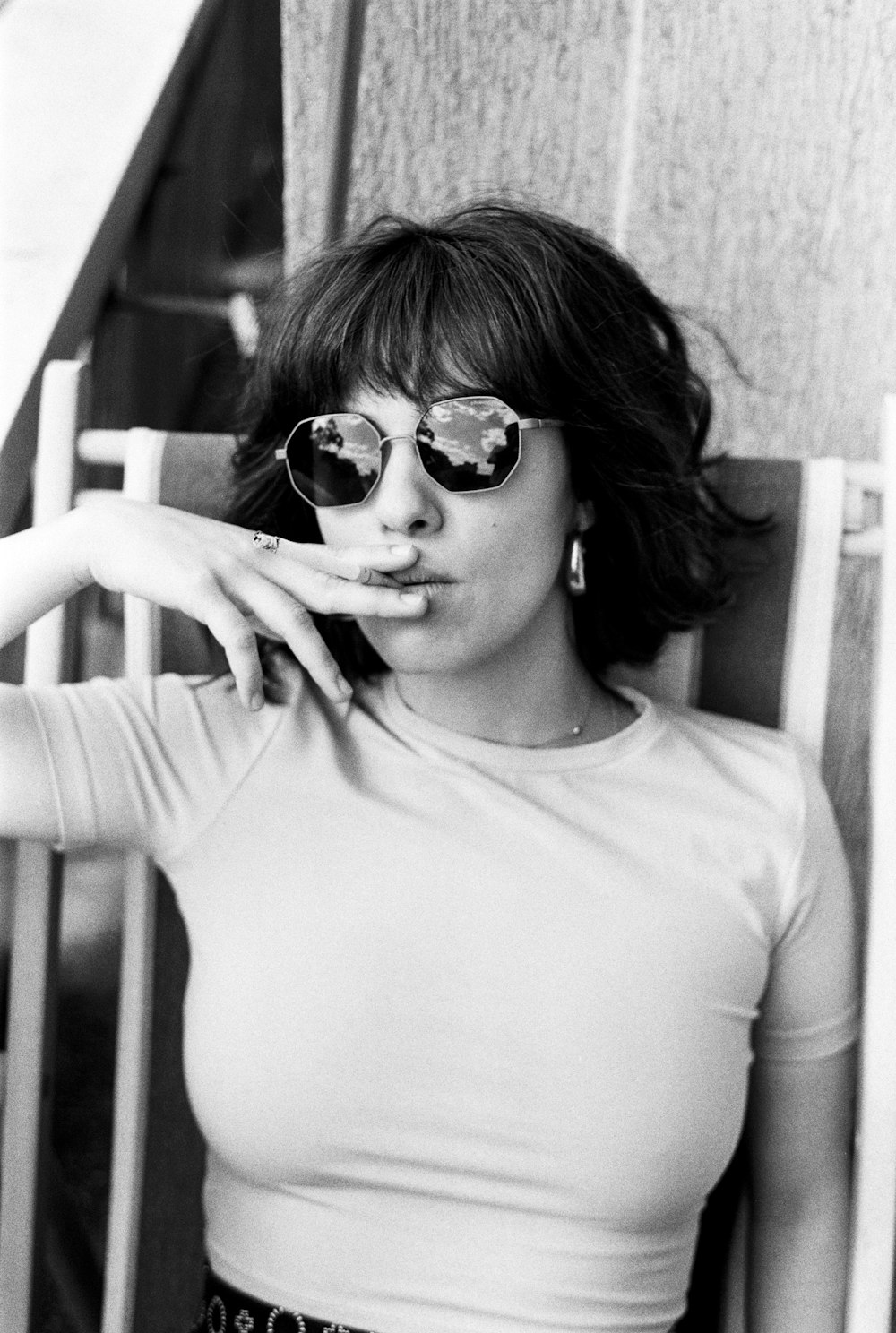 a woman wearing sunglasses smoking a cigarette