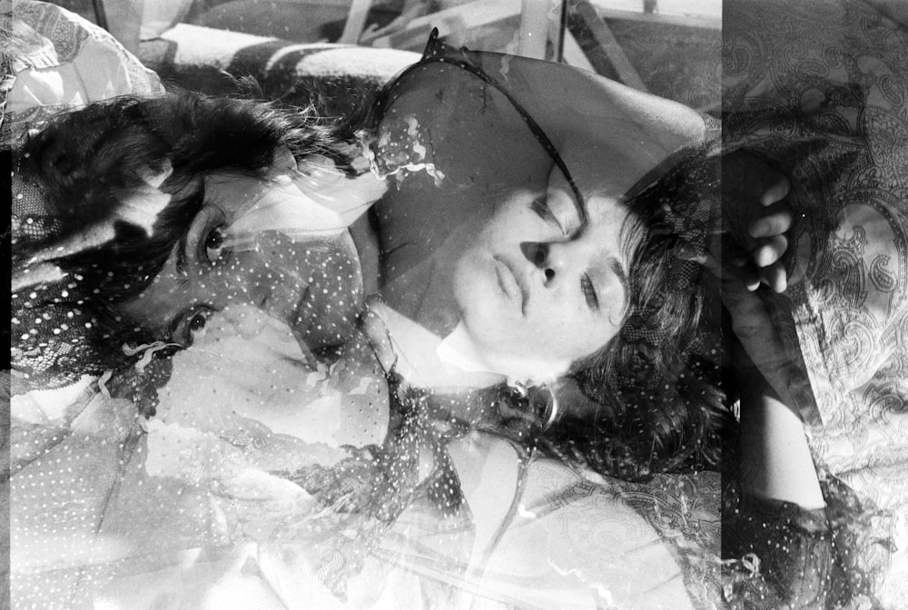 Una foto en blanco y negro de una mujer acostada en una cama