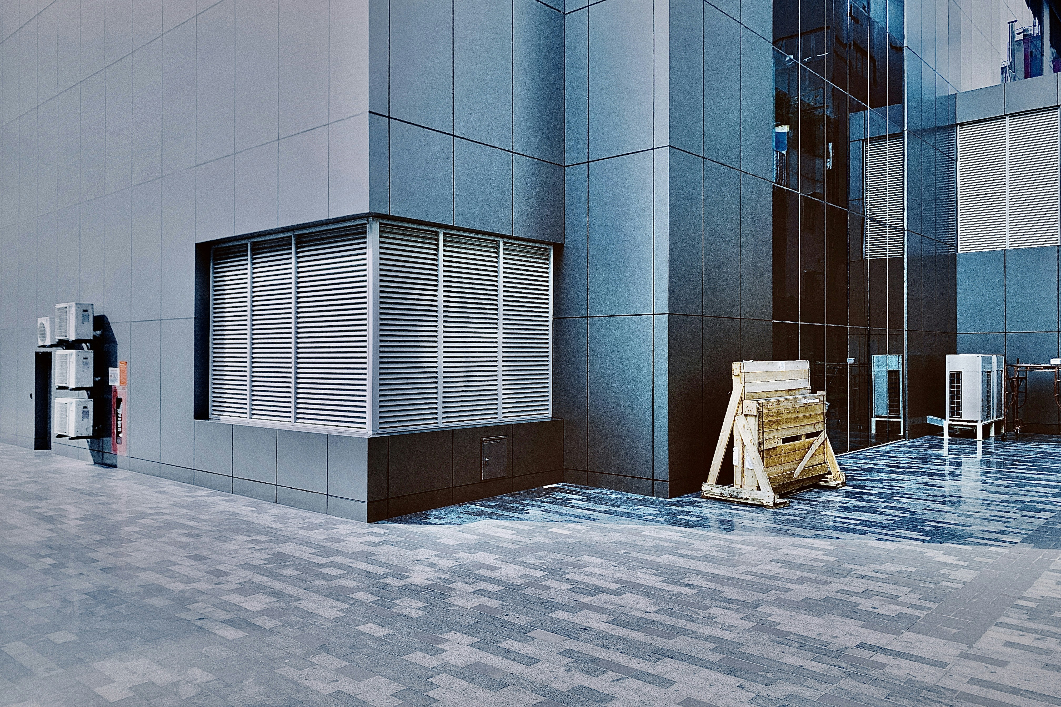 Ein Mann, der an einem hohen Gebäude neben einer Parkuhr vorbeigeht