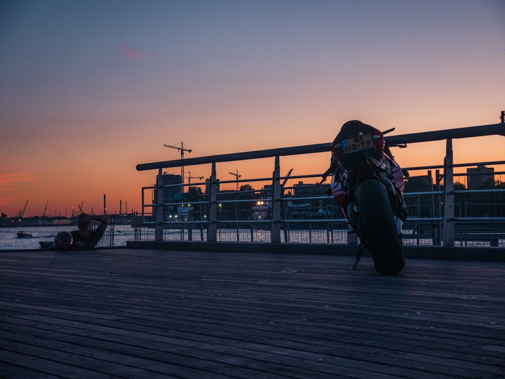 a person sitting on a bench at sunset