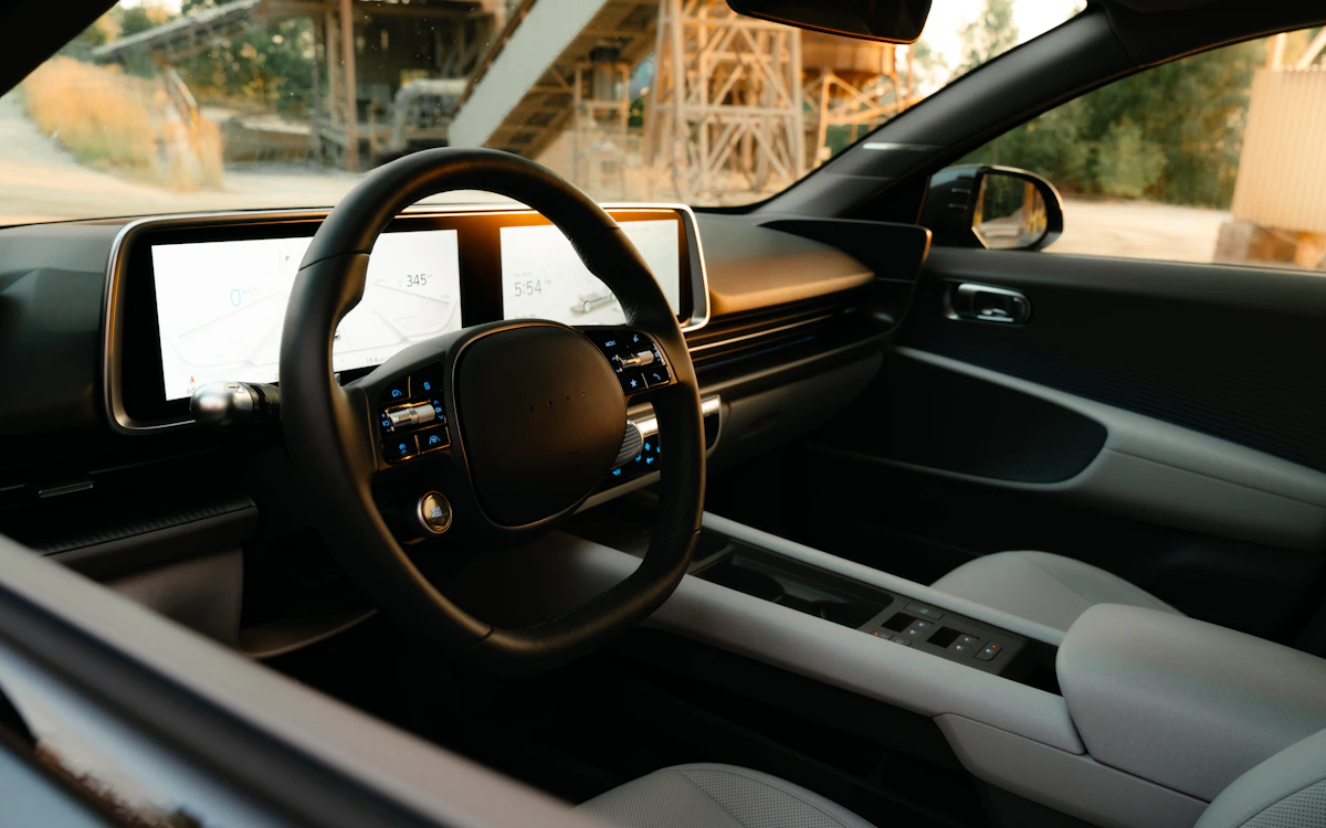 A refined modern car interior with steering wheel, dashboard, display, and seating