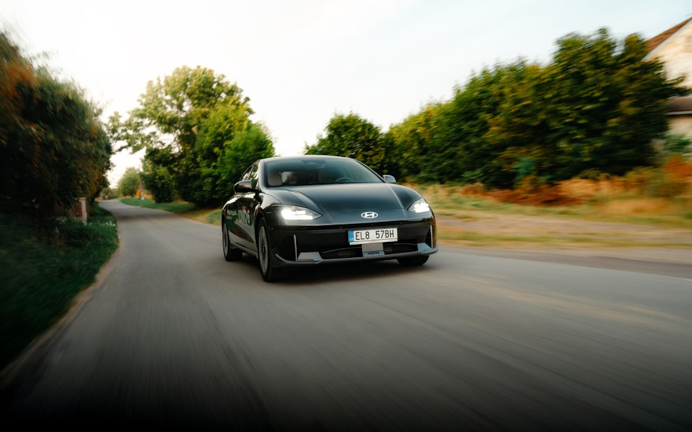 a black sports car driving down a street