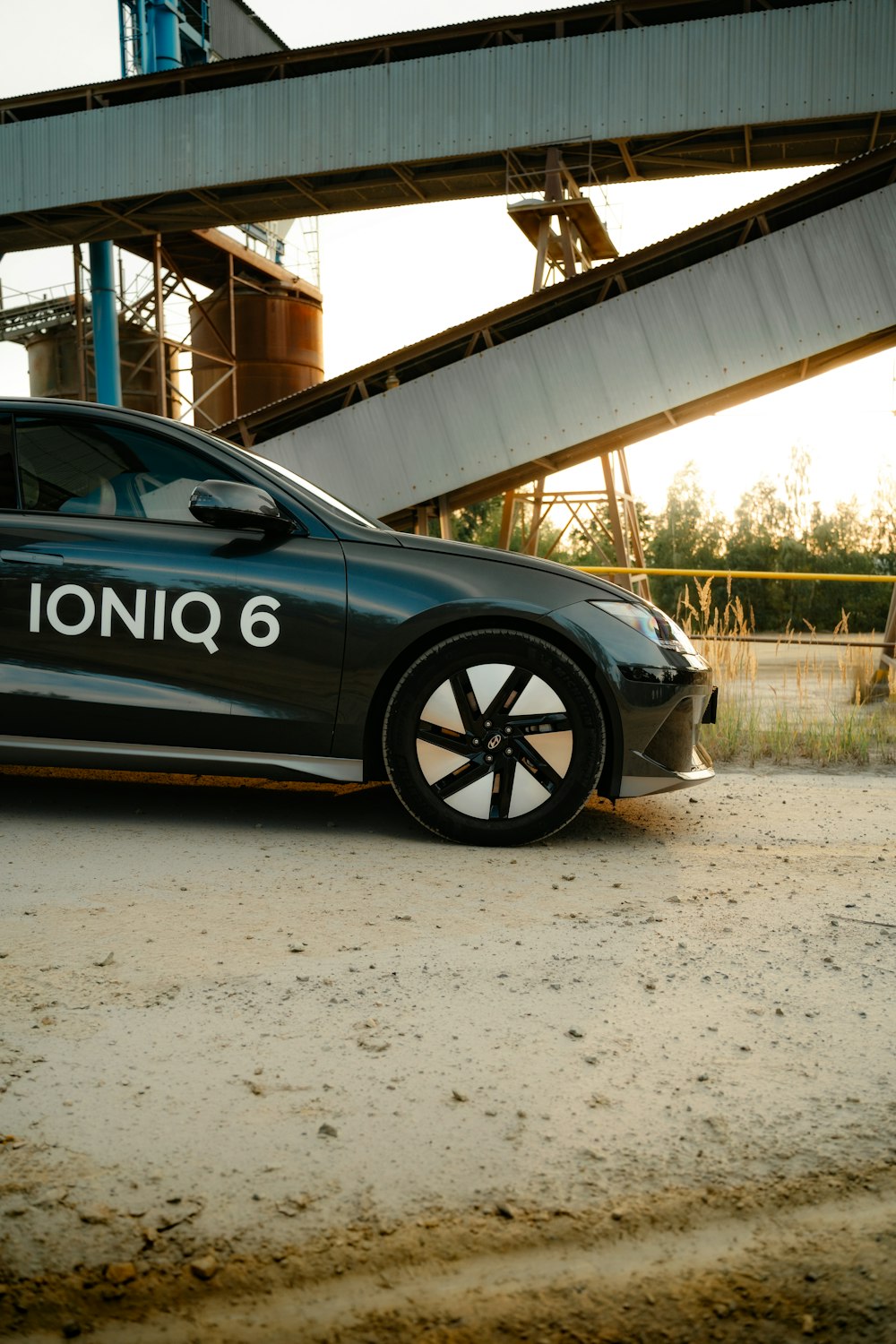 a silver car parked in front of a bridge