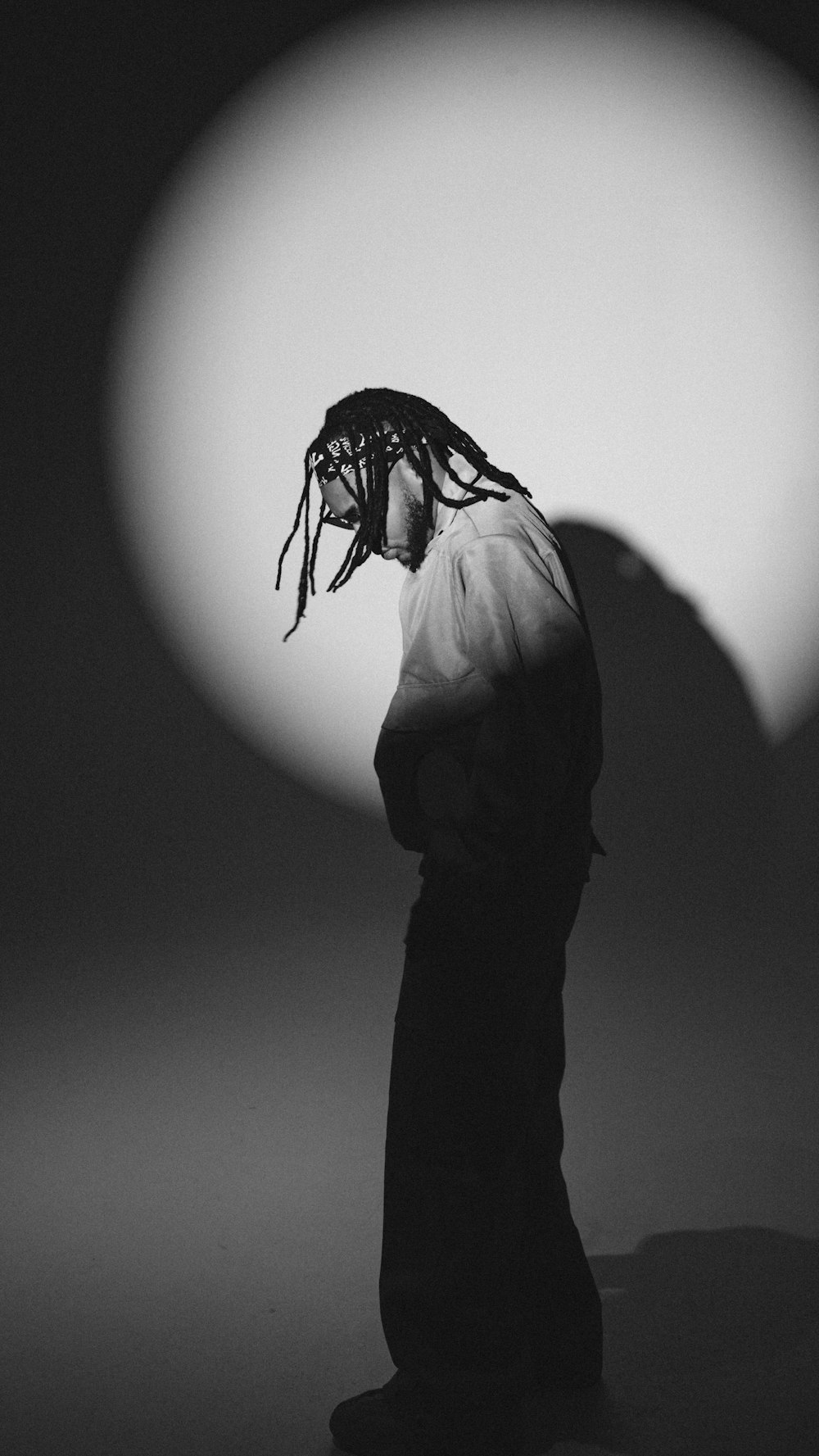 a man with dreadlocks standing in front of a sun