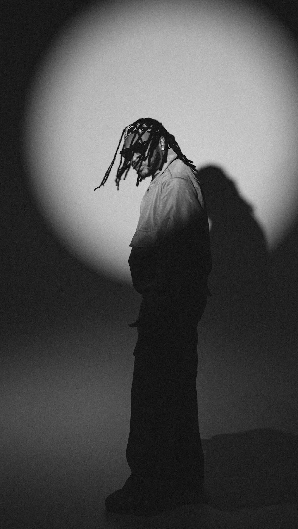 a black and white photo of a person with dreadlocks