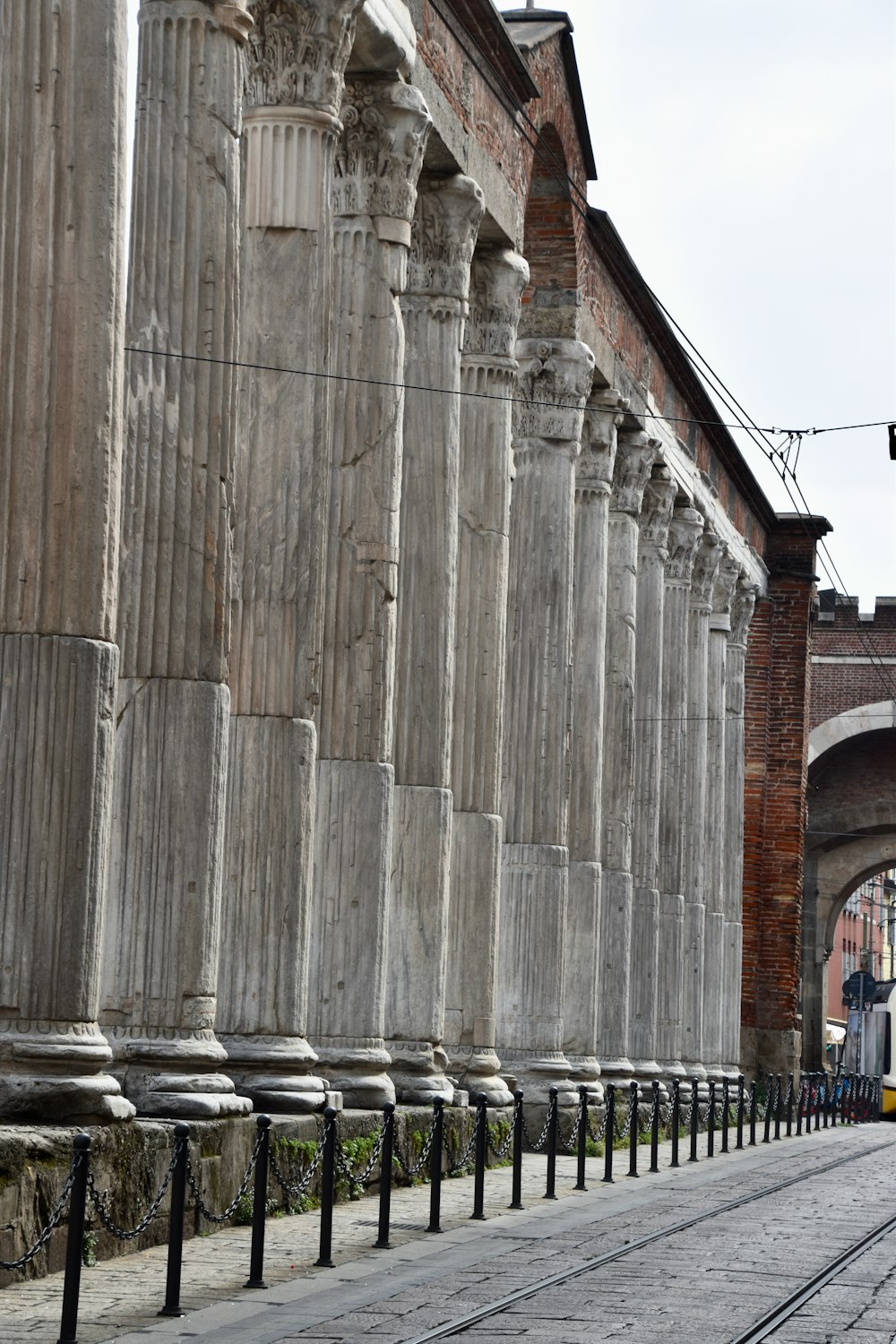 a row of stone pillars next to a train track