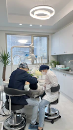 Patient receiving professional teeth whitening treatment in a bright, clean dental office.