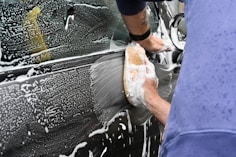 a man washing a car with a sponge