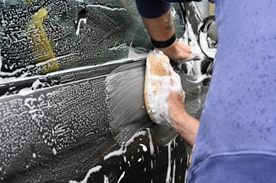 a man washing a car with a sponge