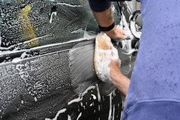 a man washing a car with a sponge