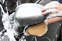 a person washing a car with a sponge