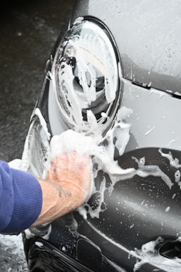 a person washing a car with a sponge